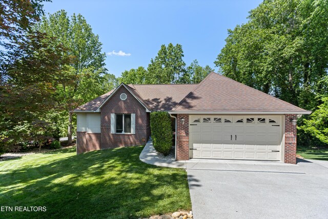 407 Tecumseh Pt, Loudon, TN 37774 - view of front of house featuring brick siding, a front yard, concrete driveway, and roof with shingles