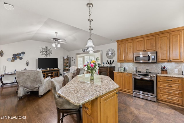 407 Tecumseh Pt, Loudon, TN 37774 - kitchen with appliances with stainless steel finishes, light stone countertops, tasteful backsplash, a breakfast bar area, and vaulted ceiling