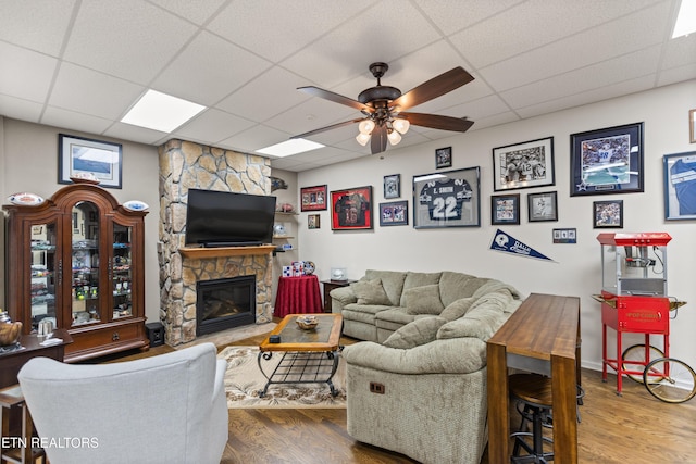 407 Tecumseh Pt, Loudon, TN 37774 - living room featuring wood finished floors, a drop ceiling, a ceiling fan, and a fireplace
