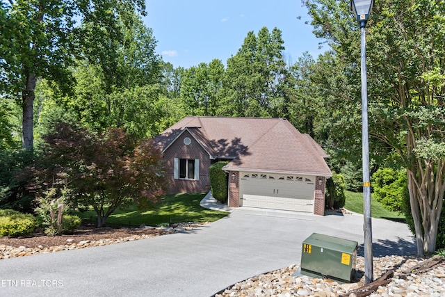 407 Tecumseh Pt, Loudon, TN 37774 - view of front of property featuring brick siding, concrete driveway, an attached garage, and a front lawn