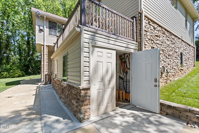 407 Tecumseh Pt, Loudon, TN 37774 - property entrance with stone siding, a balcony, and an attached garage