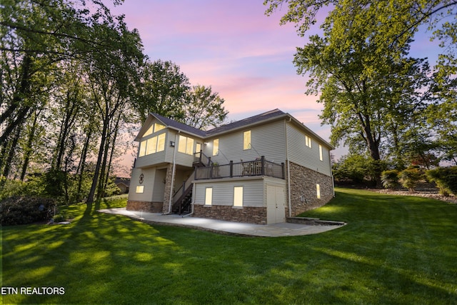 407 Tecumseh Pt, Loudon, TN 37774 - back of property at dusk featuring stone siding, a patio area, a yard, and stairway