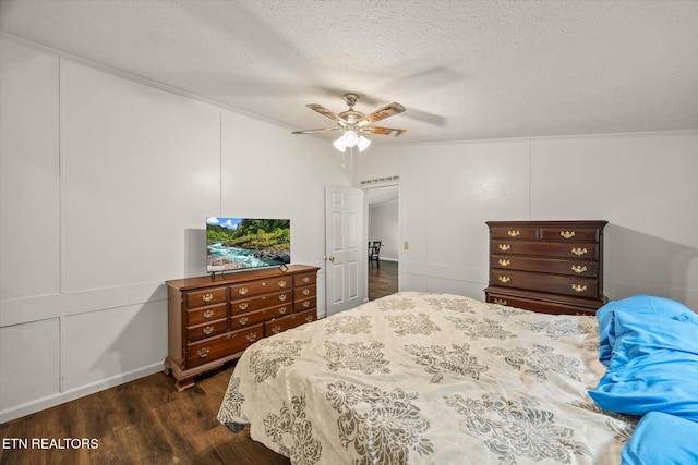 938 Riley Creek Rd, Whitleyville, TN 38588 - bedroom featuring dark wood-style floors, a decorative wall, a textured ceiling, and a ceiling fan