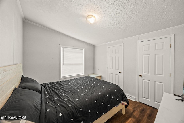 938 Riley Creek Rd, Whitleyville, TN 38588 - bedroom featuring vaulted ceiling, dark wood-style floors, and a textured ceiling