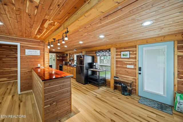 938 Riley Creek Rd, Whitleyville, TN 38588 - kitchen with wood counters, freestanding refrigerator, wood walls, wood ceiling, and light wood-style flooring