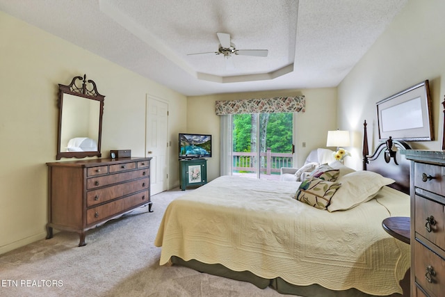 45 Calderwood Cir, Fairfield Glade, TN 38558 - bedroom with light carpet, access to outside, a textured ceiling, a tray ceiling, and a ceiling fan