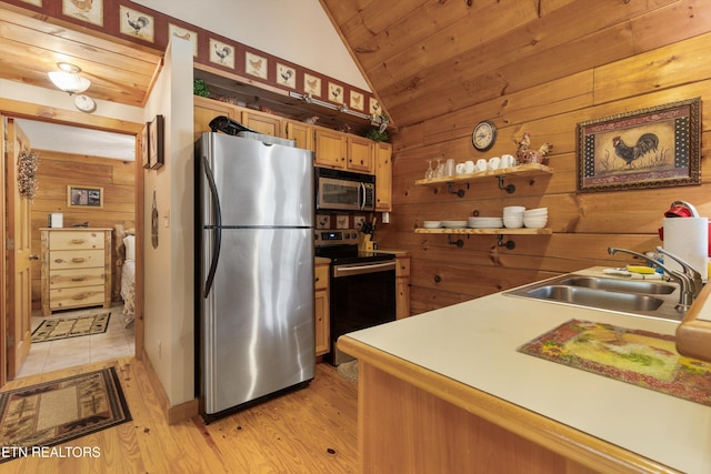 214 Tsali Way, Sevierville, TN 37876 - kitchen featuring appliances with stainless steel finishes, a sink, wood walls, lofted ceiling, and light wood-style flooring