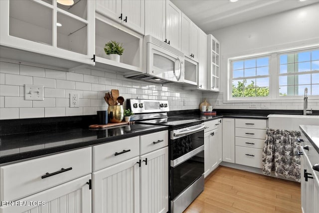 309 Southshore Dr, Greenback, TN 37742 - kitchen featuring stainless steel range with electric stovetop, white microwave, a sink, white cabinets, and backsplash