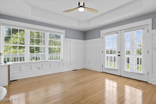 309 Southshore Dr, Greenback, TN 37742 - empty room with a decorative wall, a raised ceiling, a ceiling fan, french doors, and light wood finished floors