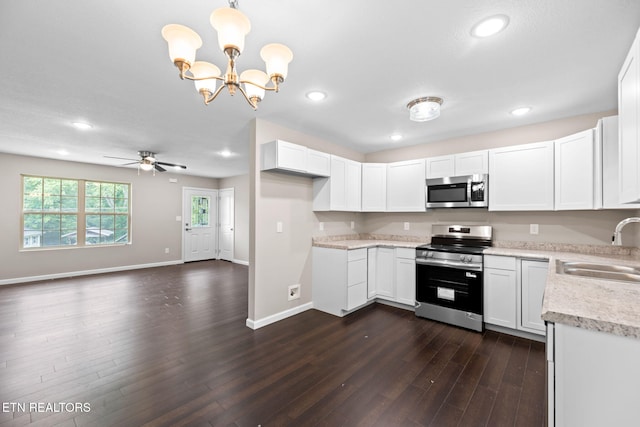 109 Ivy Ln, Oak Ridge, TN 37830 - kitchen with appliances with stainless steel finishes, dark wood-style floors, white cabinets, recessed lighting, and a chandelier