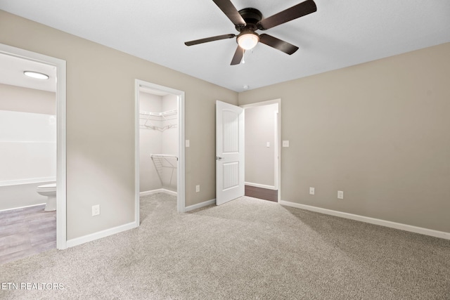 109 Ivy Ln, Oak Ridge, TN 37830 - unfurnished bedroom with a walk in closet, carpet, a closet, connected bathroom, and a ceiling fan