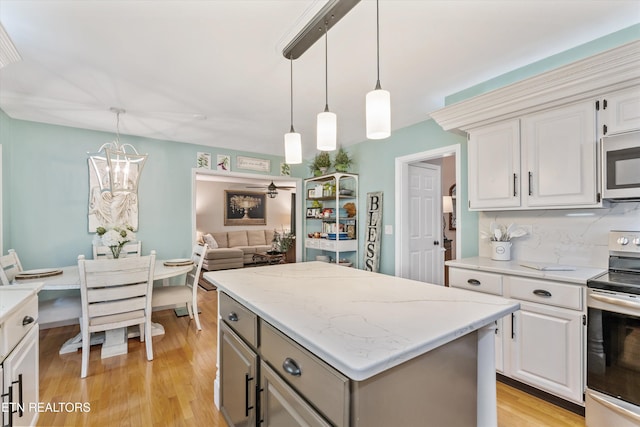 109 Cheeskogili Way, Loudon, TN 37774 - kitchen with appliances with stainless steel finishes, a center island, light wood finished floors, decorative light fixtures, and white cabinets