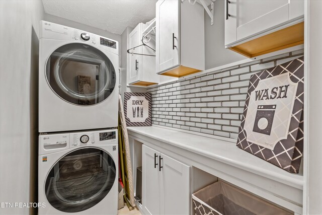 109 Cheeskogili Way, Loudon, TN 37774 - washroom with stacked washer and clothes dryer, cabinet space, and a textured ceiling