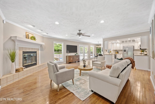 11514 Dobe Way, Knoxville, TN 37932 - living area with crown molding, light wood-style floors, ceiling fan, recessed lighting, and a tiled fireplace