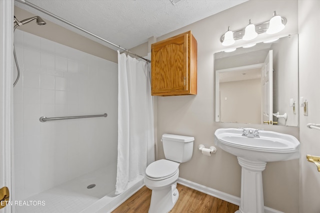 11514 Dobe Way, Knoxville, TN 37932 - full bath featuring wood finished floors, tiled shower, toilet, a textured ceiling, and baseboards