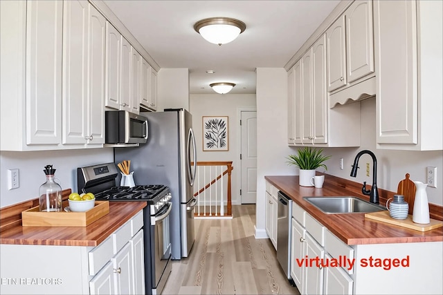 422 Willow Tree Ln, Morristown, TN 37814 - kitchen with butcher block countertops, appliances with stainless steel finishes, light wood finished floors, and white cabinets