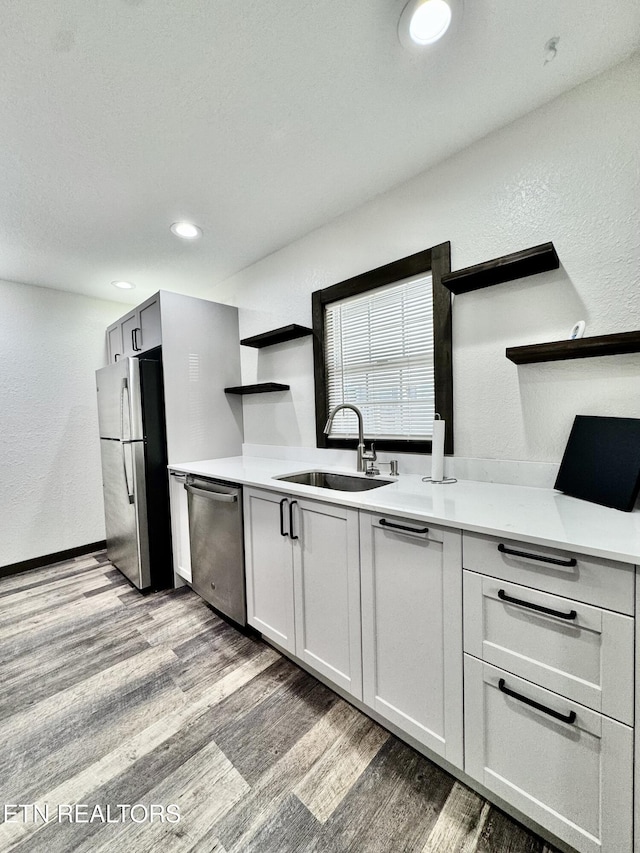 321 Coleman St, Harrogate, TN 37752 - kitchen with open shelves, appliances with stainless steel finishes, light wood-type flooring, a sink, and a textured wall