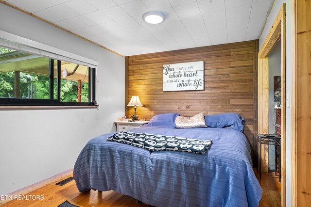4884 Jones Cove Rd, Cosby, TN 37722 - bedroom featuring wood walls, wood finished floors, an accent wall, and baseboards