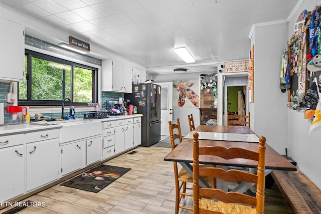 4884 Jones Cove Rd, Cosby, TN 37722 - kitchen with stainless steel refrigerator with ice dispenser, light countertops, white cabinets, light wood finished floors, and a sink