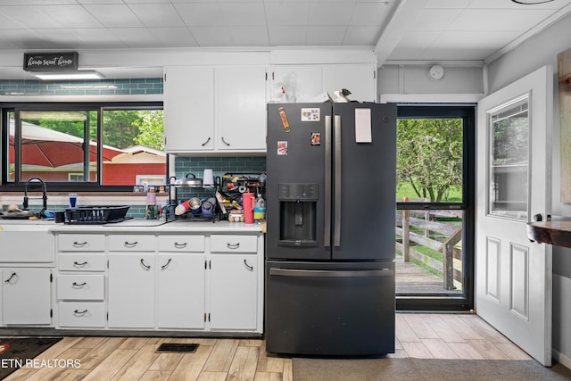 4884 Jones Cove Rd, Cosby, TN 37722 - kitchen featuring fridge with ice dispenser, light wood-type flooring, light countertops, and white cabinetry