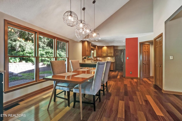 104 Maltese Ln, Oak Ridge, TN 37830 - dining room featuring dark wood finished floors, baseboards, high vaulted ceiling, and a chandelier