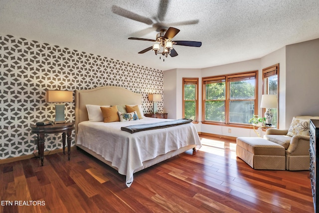 104 Maltese Ln, Oak Ridge, TN 37830 - bedroom featuring a textured ceiling, wood finished floors, wallpapered walls, baseboards, and an accent wall