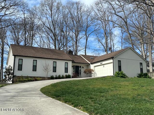 1309 Farrington Dr, Knoxville, TN 37923 - view of front facade featuring concrete driveway, a front yard, a garage, and a chimney