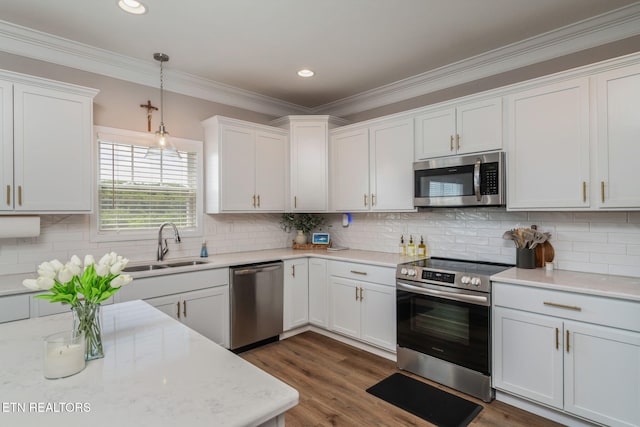 111 Chaseberry Rd, Oak Ridge, TN 37830 - kitchen featuring stainless steel appliances, white cabinetry, crown molding, hanging light fixtures, and decorative backsplash