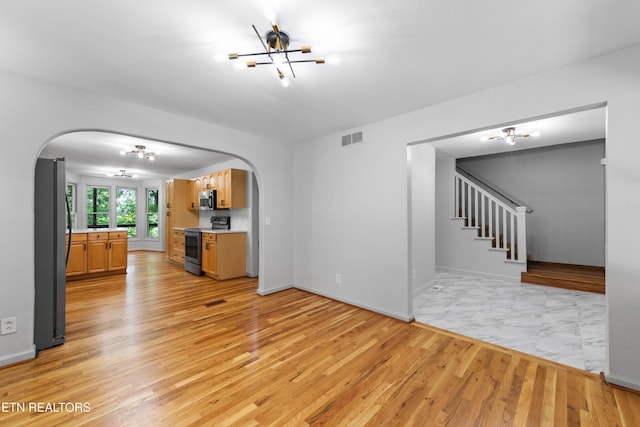 120 Kingdom Ln, Walland, TN 37886 - unfurnished living room featuring arched walkways, a chandelier, and light wood finished floors