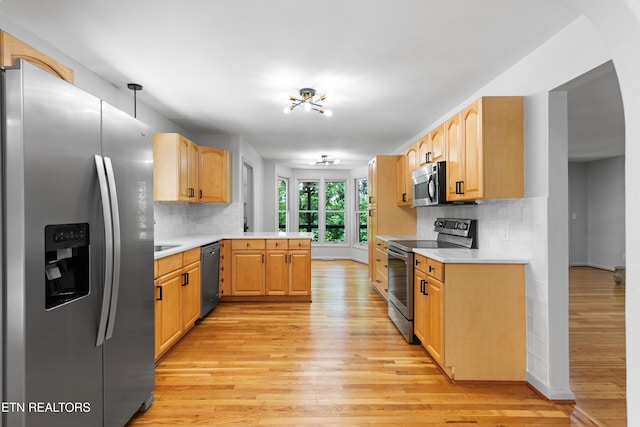 120 Kingdom Ln, Walland, TN 37886 - kitchen featuring stainless steel appliances, a peninsula, light wood finished floors, and light countertops