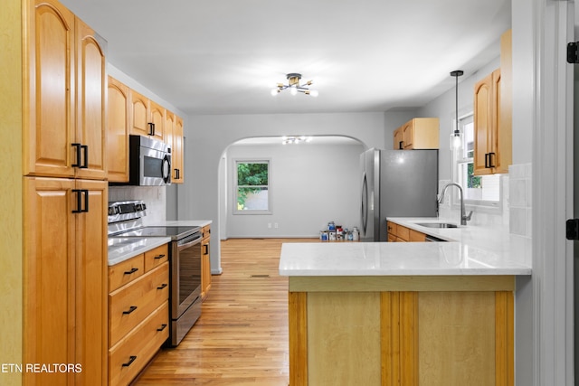120 Kingdom Ln, Walland, TN 37886 - kitchen with appliances with stainless steel finishes, a sink, arched walkways, light wood finished floors, and a peninsula