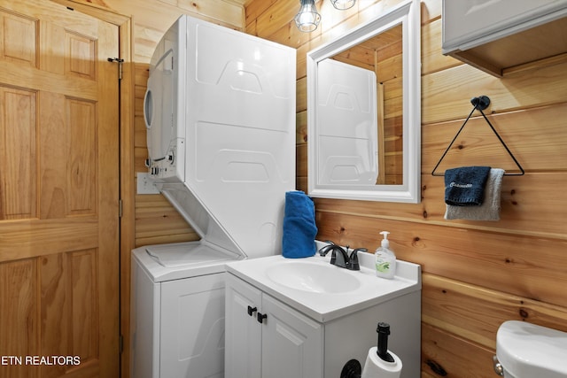 1159 Ditney Ln, Sevierville, TN 37876 - bathroom featuring stacked washer and clothes dryer, vanity, wood walls, and toilet