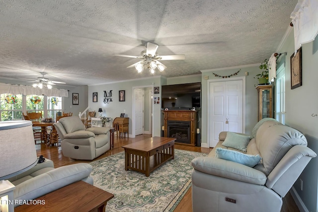 111 Ellis St, Vonore, TN 37885 - living area featuring a ceiling fan, a textured ceiling, wood finished floors, a fireplace, and ornamental molding