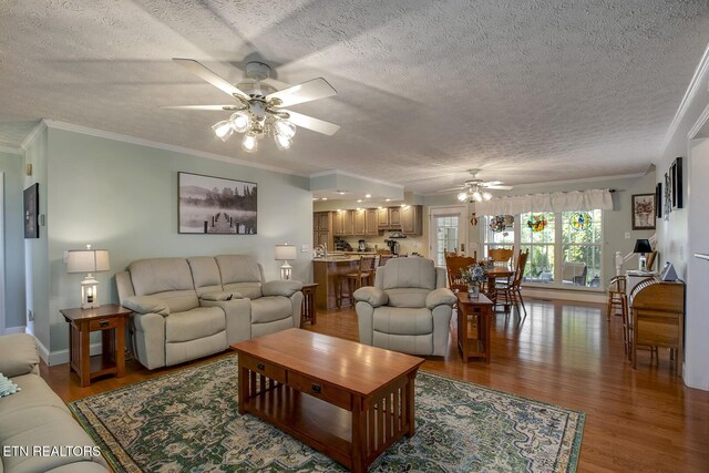 111 Ellis St, Vonore, TN 37885 - living room featuring ceiling fan, a textured ceiling, light wood-style floors, ornamental molding, and baseboards
