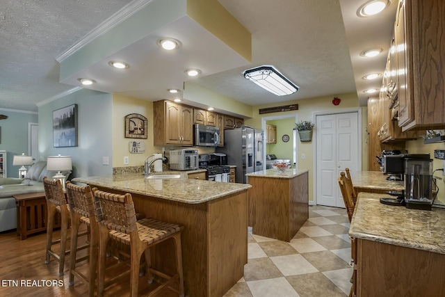111 Ellis St, Vonore, TN 37885 - kitchen with appliances with stainless steel finishes, a kitchen island, a sink, a textured ceiling, and a peninsula