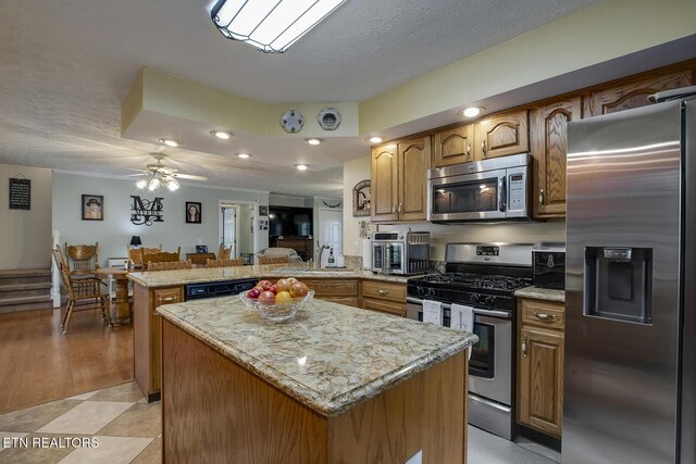 111 Ellis St, Vonore, TN 37885 - kitchen with appliances with stainless steel finishes, a peninsula, a kitchen island, a sink, and ceiling fan