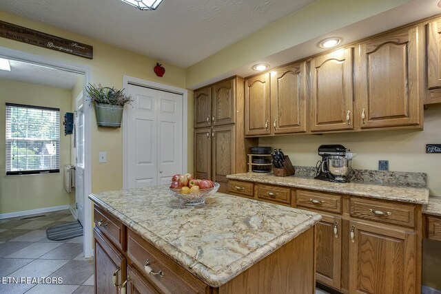 111 Ellis St, Vonore, TN 37885 - kitchen with baseboards, a center island, light stone countertops, and brown cabinets