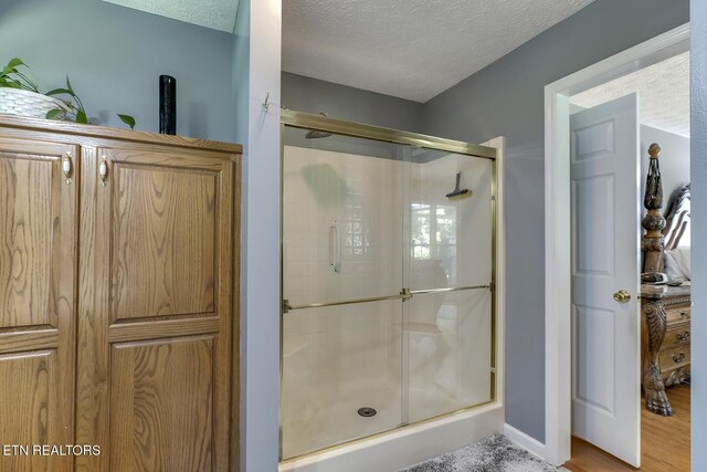 111 Ellis St, Vonore, TN 37885 - full bath featuring a shower stall, a textured ceiling, and wood finished floors