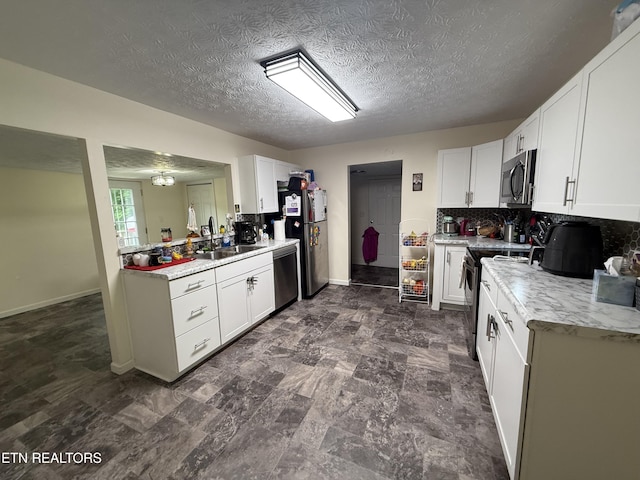 1517 W Copeland Dr, Powell, TN 37849 - kitchen with a sink, appliances with stainless steel finishes, light countertops, white cabinetry, and a textured ceiling