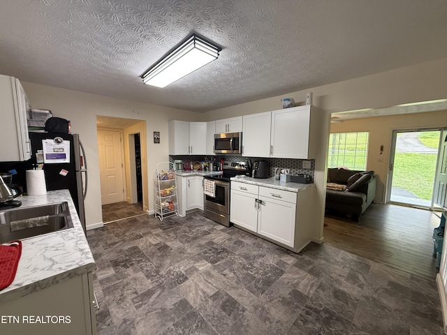 1517 W Copeland Dr, Powell, TN 37849 - kitchen featuring stainless steel appliances, white cabinets, light countertops, backsplash, and a sink