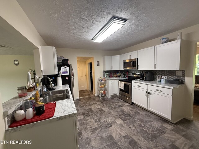 1517 W Copeland Dr, Powell, TN 37849 - kitchen with appliances with stainless steel finishes, a sink, white cabinets, tasteful backsplash, and light countertops