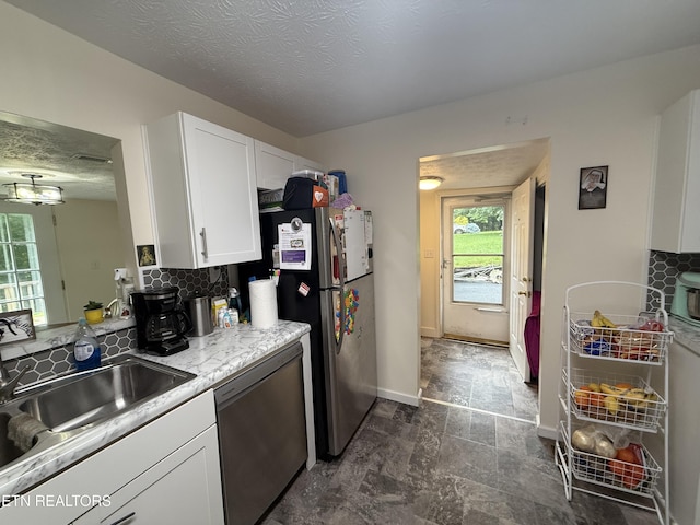 1517 W Copeland Dr, Powell, TN 37849 - kitchen with stainless steel appliances, a sink, white cabinets, light countertops, and baseboards