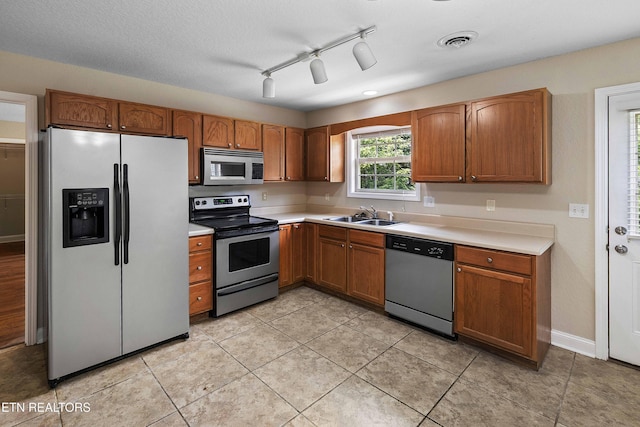 4411 Waldon Pond, Corryton, TN 37721 - kitchen with stainless steel appliances, a sink, brown cabinetry, and light countertops