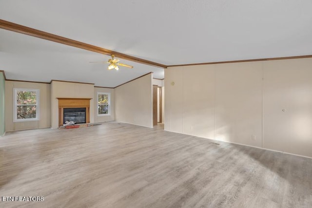 1477 Womac Hollow Rd, Ten Mile, TN 37880 - unfurnished living room featuring wood finished floors, plenty of natural light, ornamental molding, ceiling fan, and a glass covered fireplace