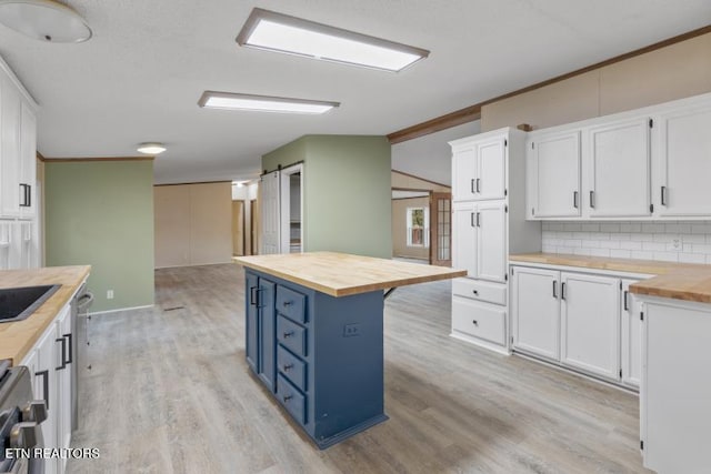 1477 Womac Hollow Rd, Ten Mile, TN 37880 - kitchen featuring butcher block counters, blue cabinets, white cabinets, backsplash, and ornamental molding