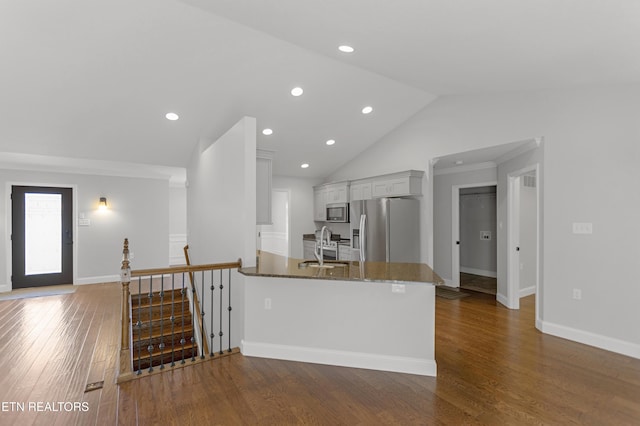 6305 Glen Eagle Ln, Knoxville, TN 37921 - kitchen featuring appliances with stainless steel finishes, dark stone countertops, dark wood finished floors, lofted ceiling, and a peninsula