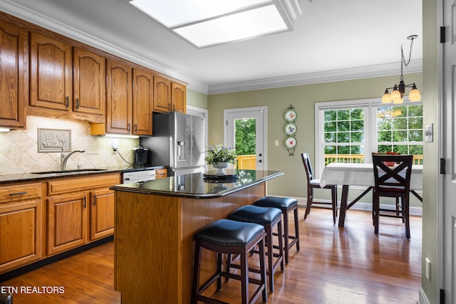 12912 Long Ridge Rd, Knoxville, TN 37934 - kitchen with a sink, crown molding, a breakfast bar area, brown cabinetry, and stainless steel fridge
