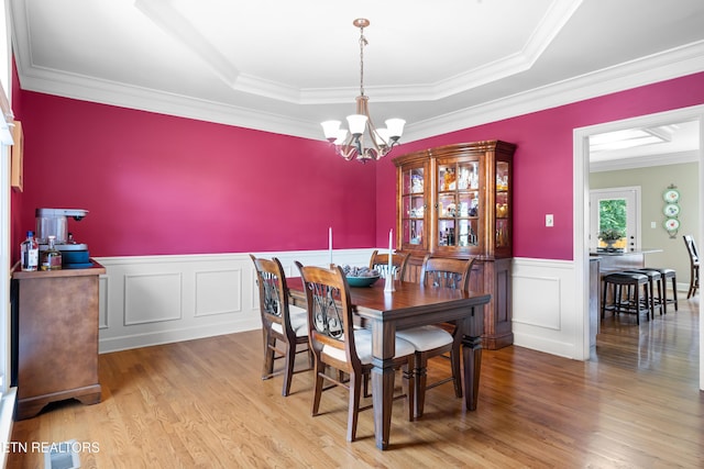 12912 Long Ridge Rd, Knoxville, TN 37934 - dining area featuring a chandelier, a raised ceiling, a wainscoted wall, wood finished floors, and crown molding