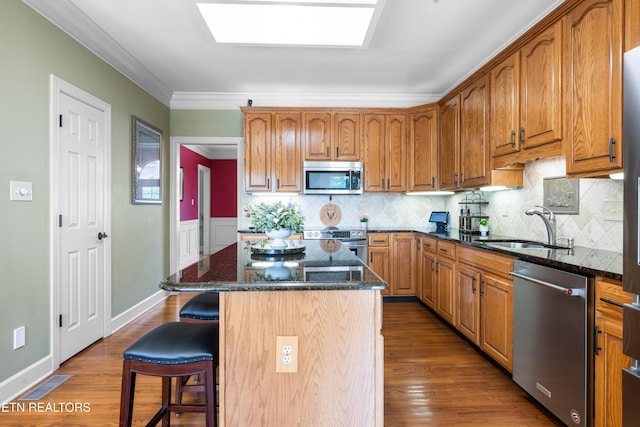 12912 Long Ridge Rd, Knoxville, TN 37934 - kitchen with stainless steel appliances, a sink, dark stone countertops, a breakfast bar, and wood finished floors