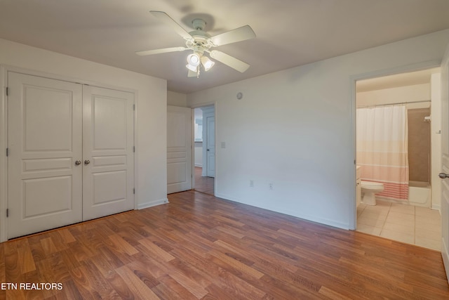 3950 Cherokee Woods Way Unit 105, Knoxville, TN 37920 - unfurnished bedroom featuring wood finished floors, a closet, baseboards, and connected bathroom